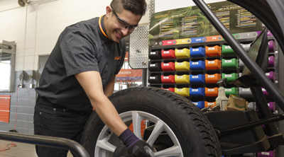 Kal Tire team member changing tire